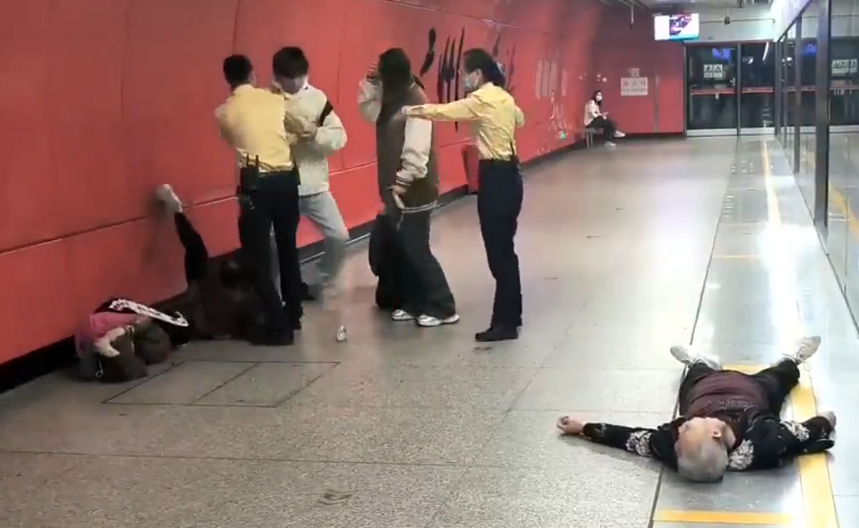 廣州地鐵站周三有一對青年男女與3名長者互毆,其中1名白髮男子倒地,地鐵工作人員上前勸阻。(影片截圖)