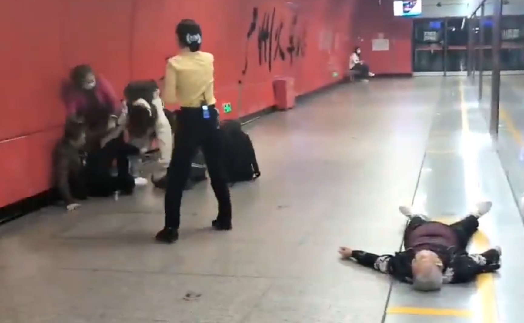 廣州地鐵站周三有一對青年男女與3名長者互毆,其中1名白髮男子倒地,地鐵工作人員上前勸阻。(影片截圖)