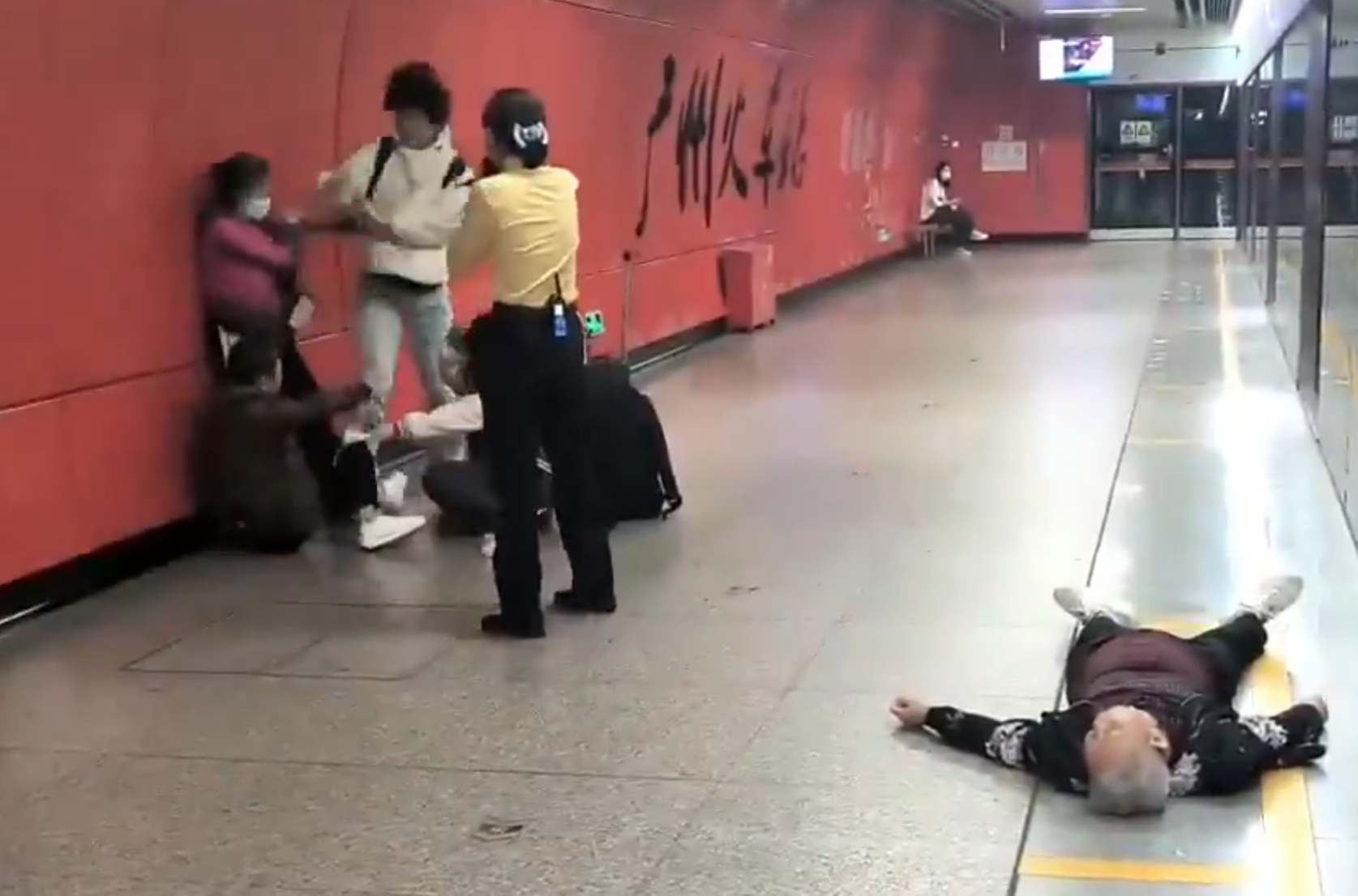 廣州地鐵站周三有一對青年男女與3名長者互毆,其中1名白髮男子倒地,地鐵工作人員上前勸阻。(影片截圖)