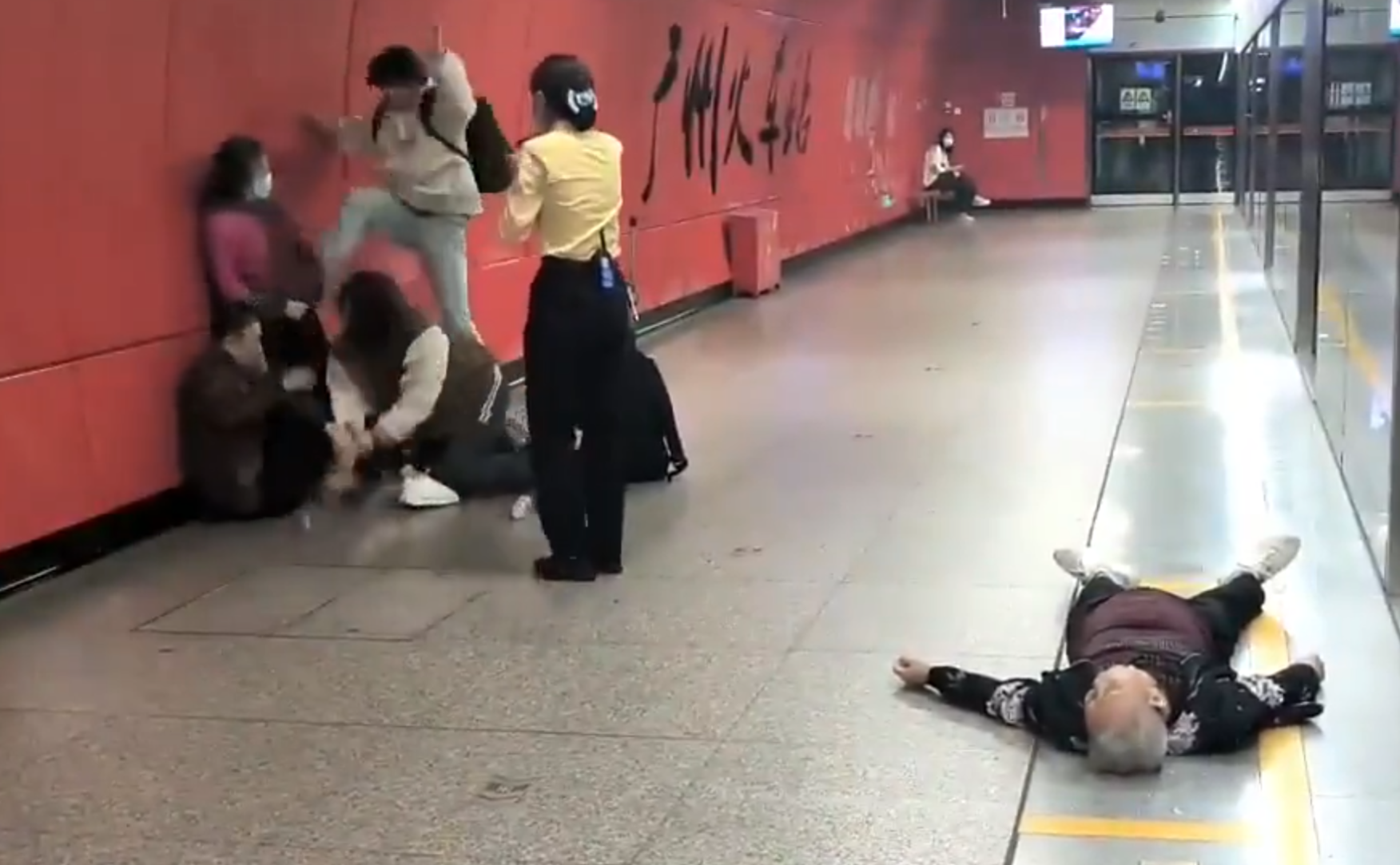 廣州地鐵站周三有一對青年男女與3名長者互毆,其中1名白髮男子倒地,地鐵工作人員上前勸阻。(影片截圖)