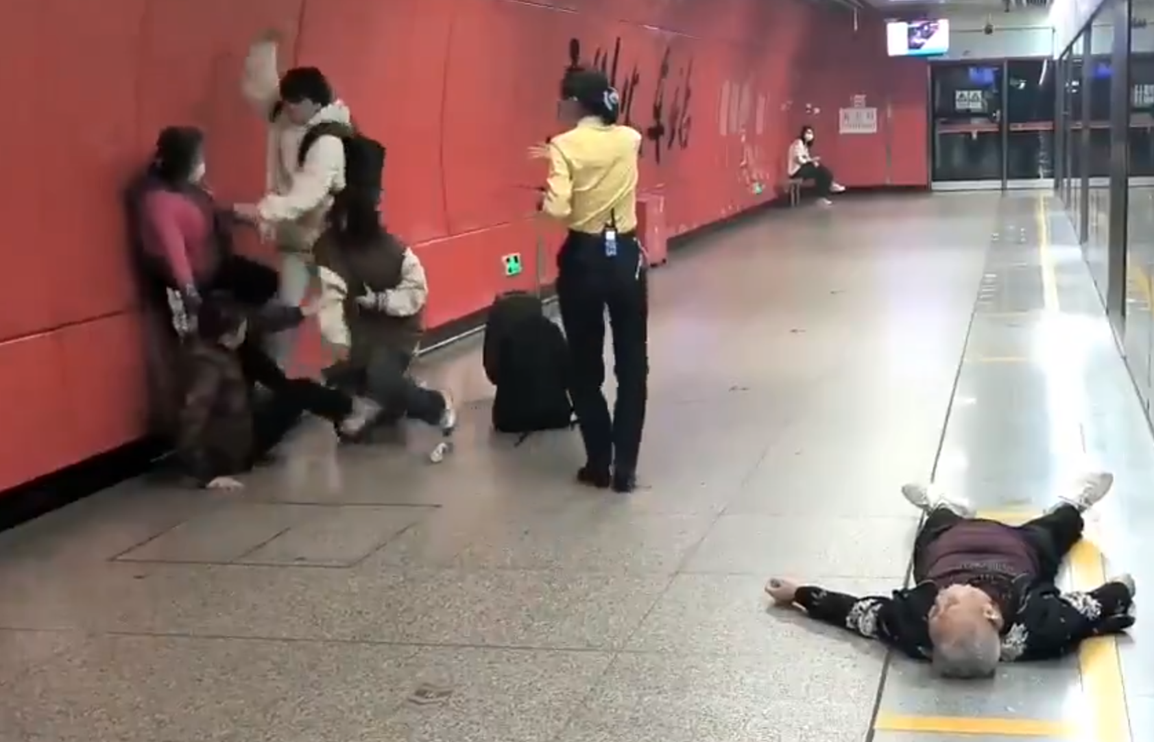 廣州地鐵站周三有一對青年男女與3名長者互毆,其中1名白髮男子倒地,地鐵工作人員上前勸阻。(影片截圖)