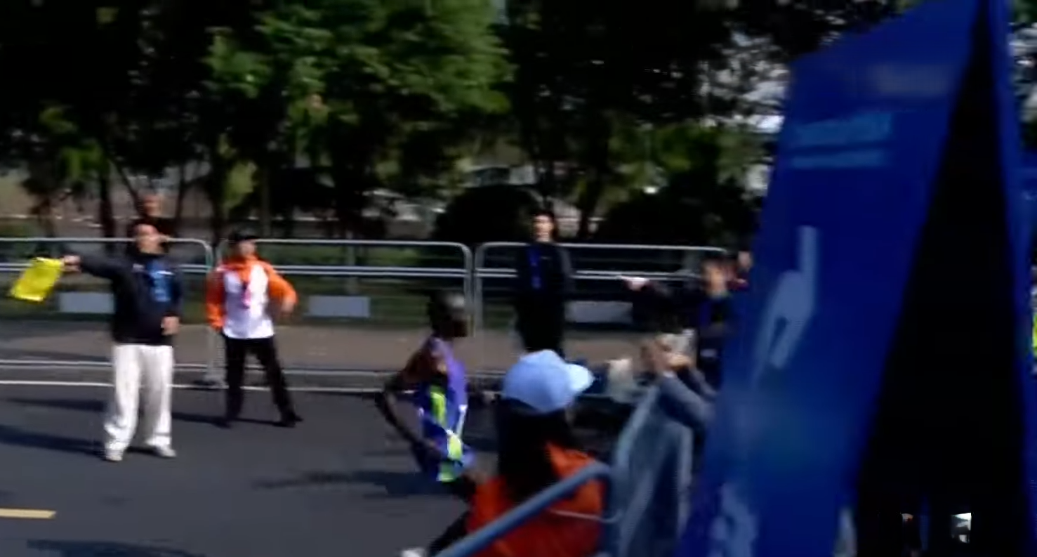 杭州馬拉松2024,Moses Kibet(紫衫)與Tesfaye Deriba同被工作人員指錯路,但前者較快回身。