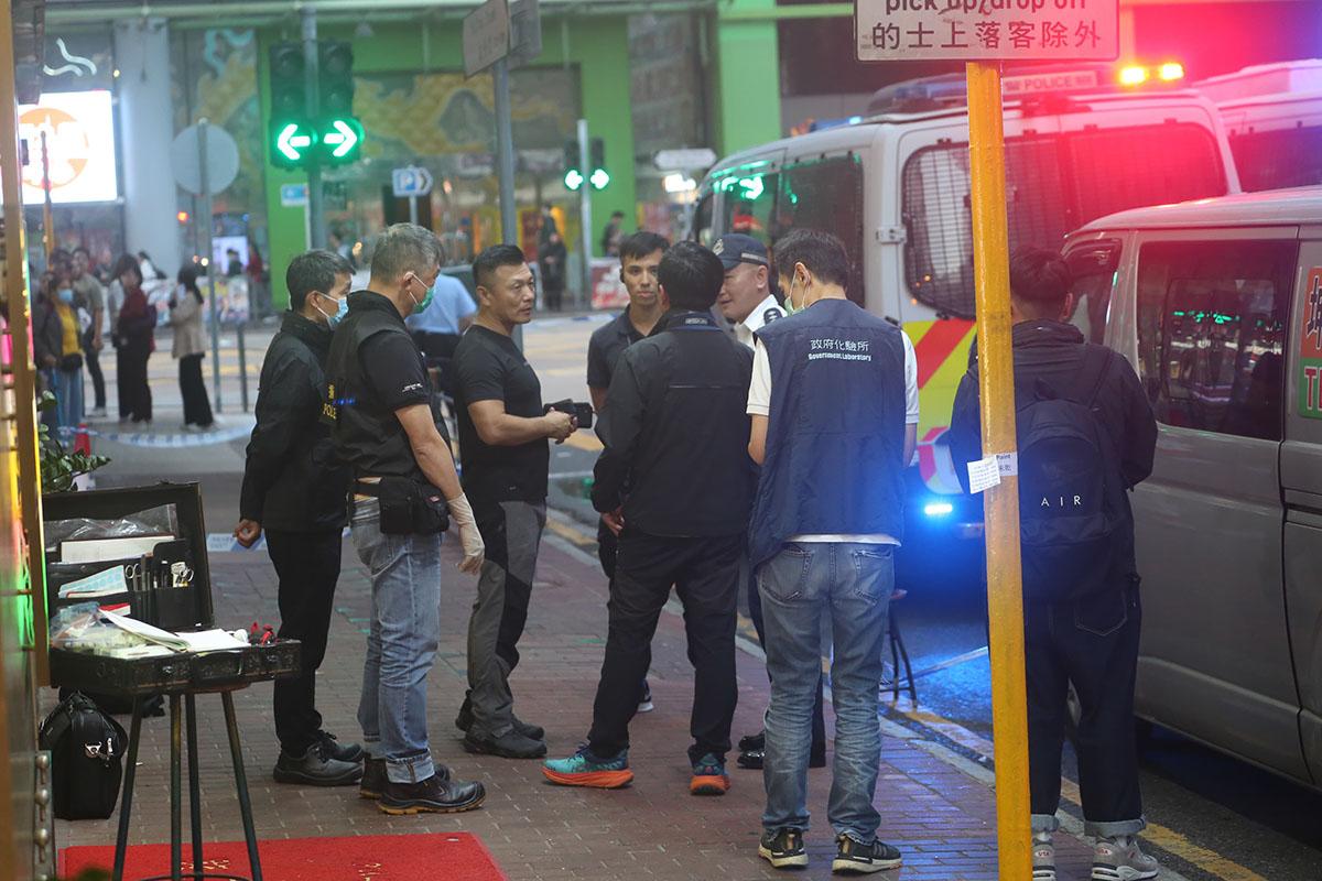 大批警員和政府化驗所人員在客貨車外調查。