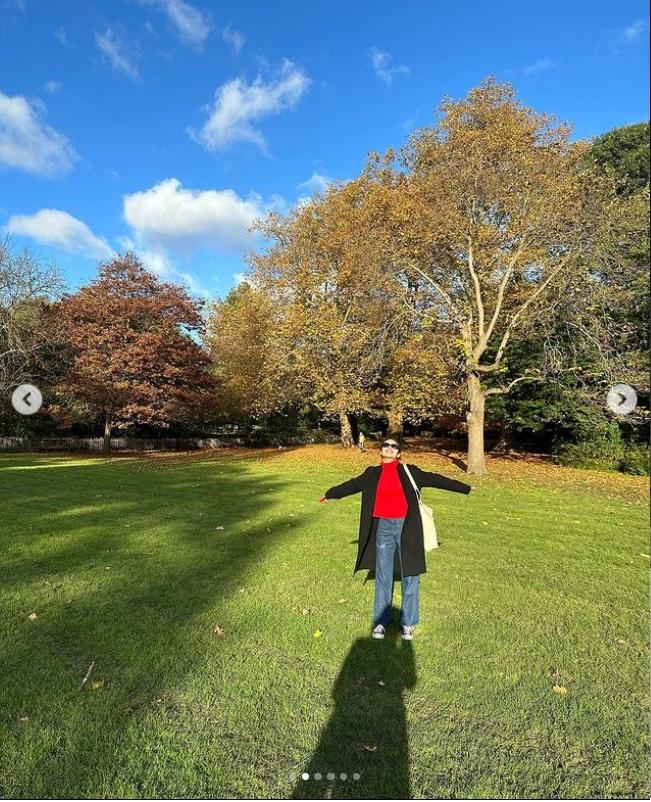 Olivia在戶外拍攝的照片,身穿紅色上衣和牛仔褲,展現獨到穿著品味。