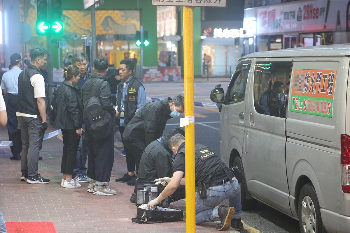 大批警員和政府化驗所人員在客貨車外調查。