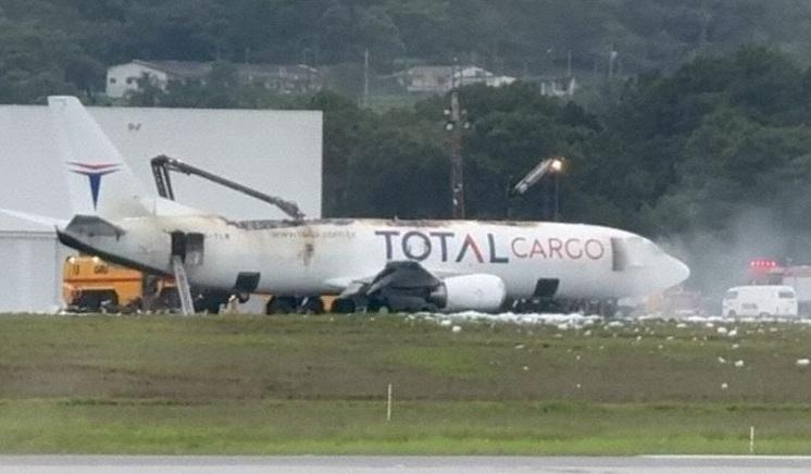 貨機緊急降落,機身不斷冒煙,消防用化學泡沬救火。(互聯網)