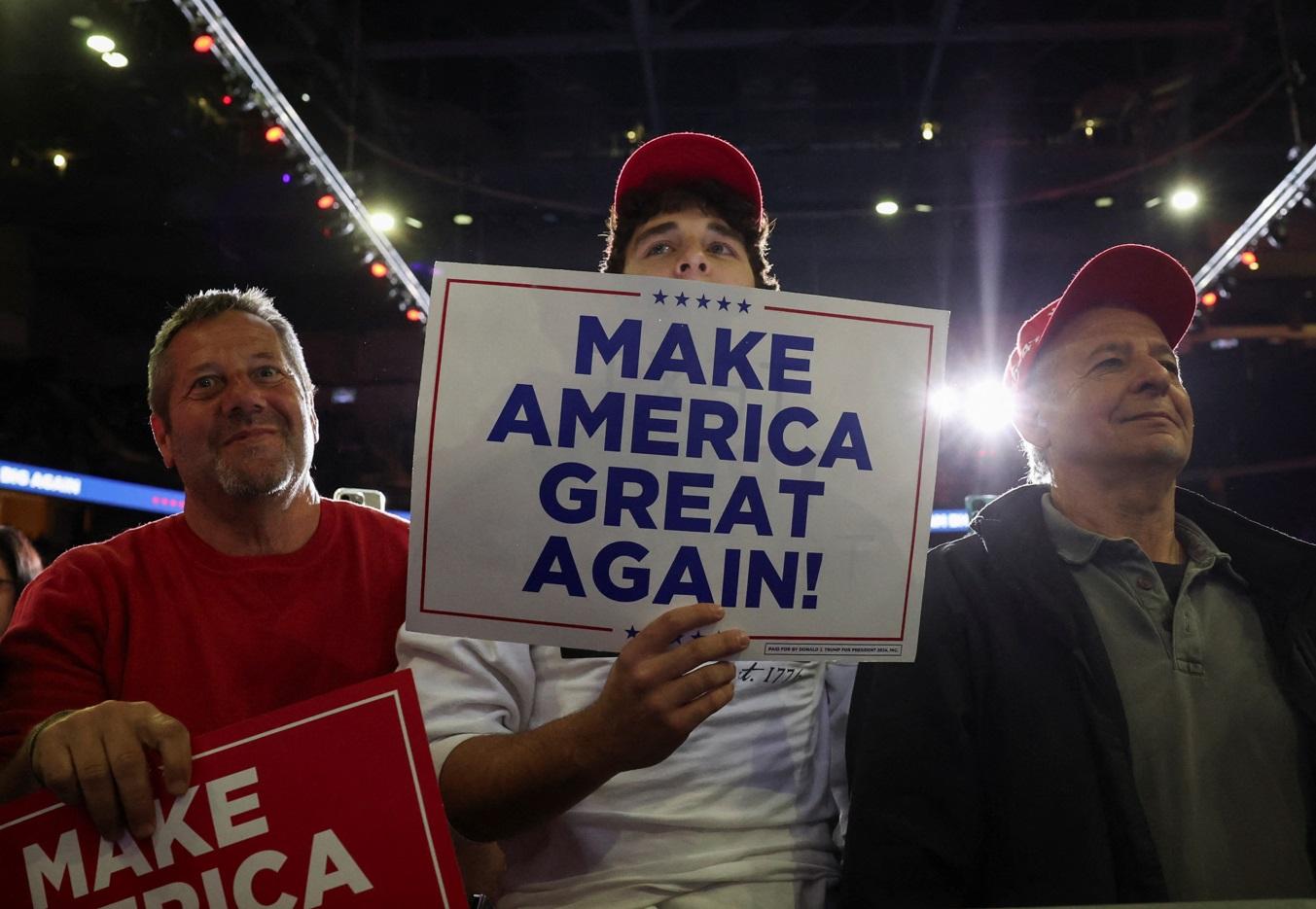 特朗普支持者在集會上展示「讓美國再次偉大」標語。(路透社)