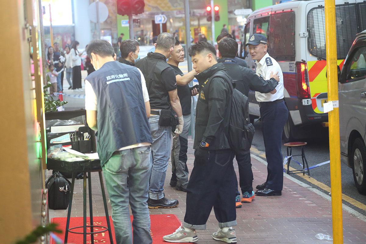 大批警員和政府化驗所人員在客貨車外調查。