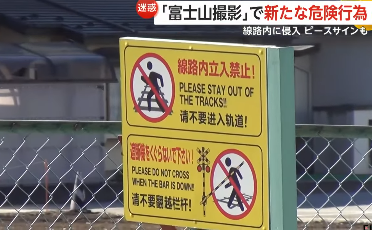 平交道前面可見設有警告牌,以日文、英文及中文寫明「請不要進入軌道」和「請不要翻越欄杆」(影片截圖)