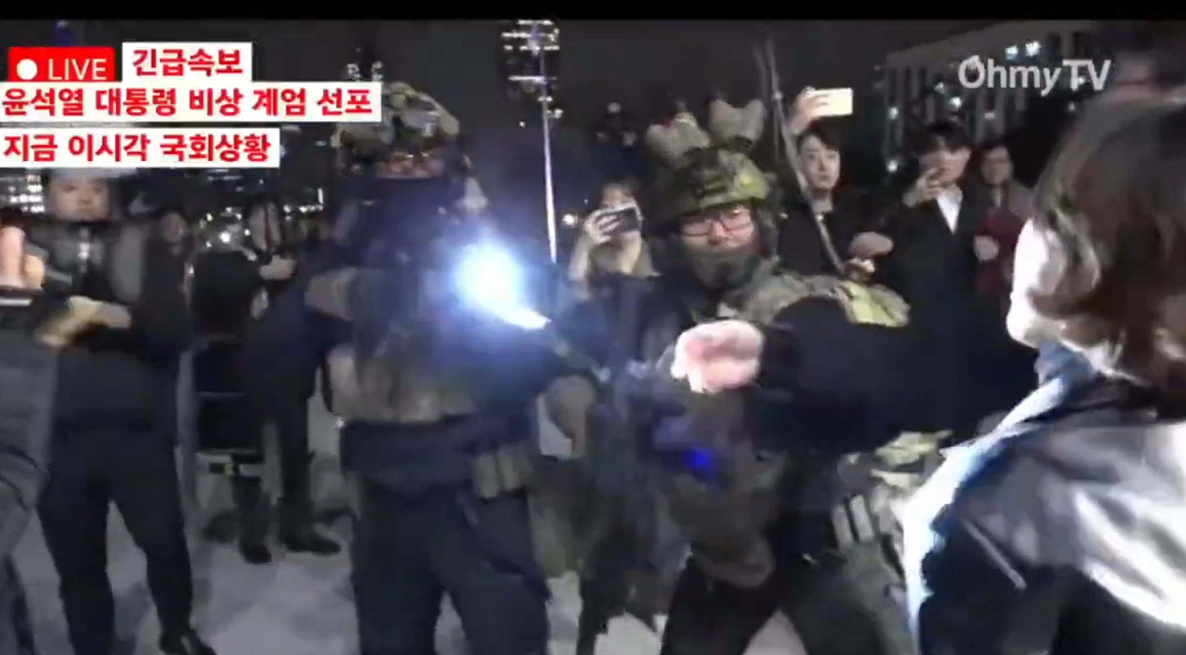 南韓戒嚴風波|戒嚴部隊人員抵達國會後與議員及工作人員互有推撞,混亂中有部隊成員懷疑用長槍指向一名女子 (影片截圖)