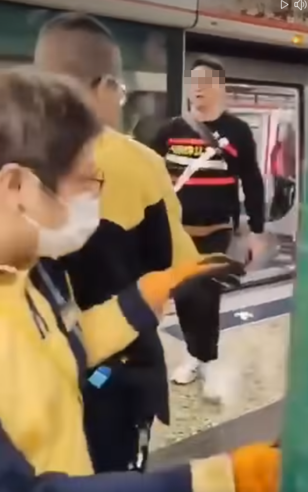 一名戴眼鏡男子手持一樽可樂游走車廂與月台,在月台作勢潑灑可樂,及後接連「起飛腳」踢向兩名手持對講機的男女港鐵職員(影片截圖)
