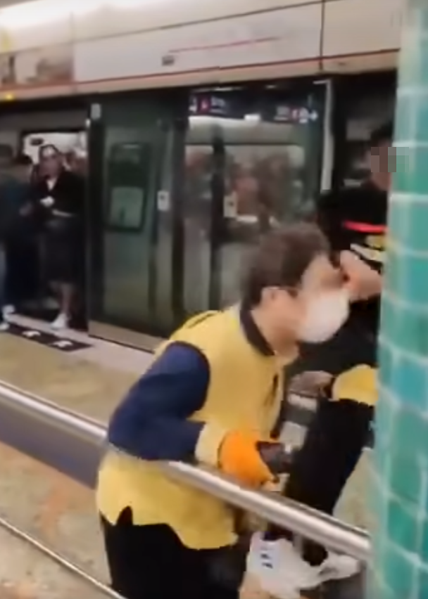 女職員遭踢中左腹,當場慘叫,掩着捱踢位置蹲下,同被踢的男職員未見大礙(影片截圖)