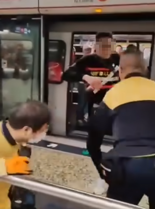 女職員遭踢中左腹,當場慘叫,掩着捱踢位置蹲下,同被踢的男職員未見大礙(影片截圖)