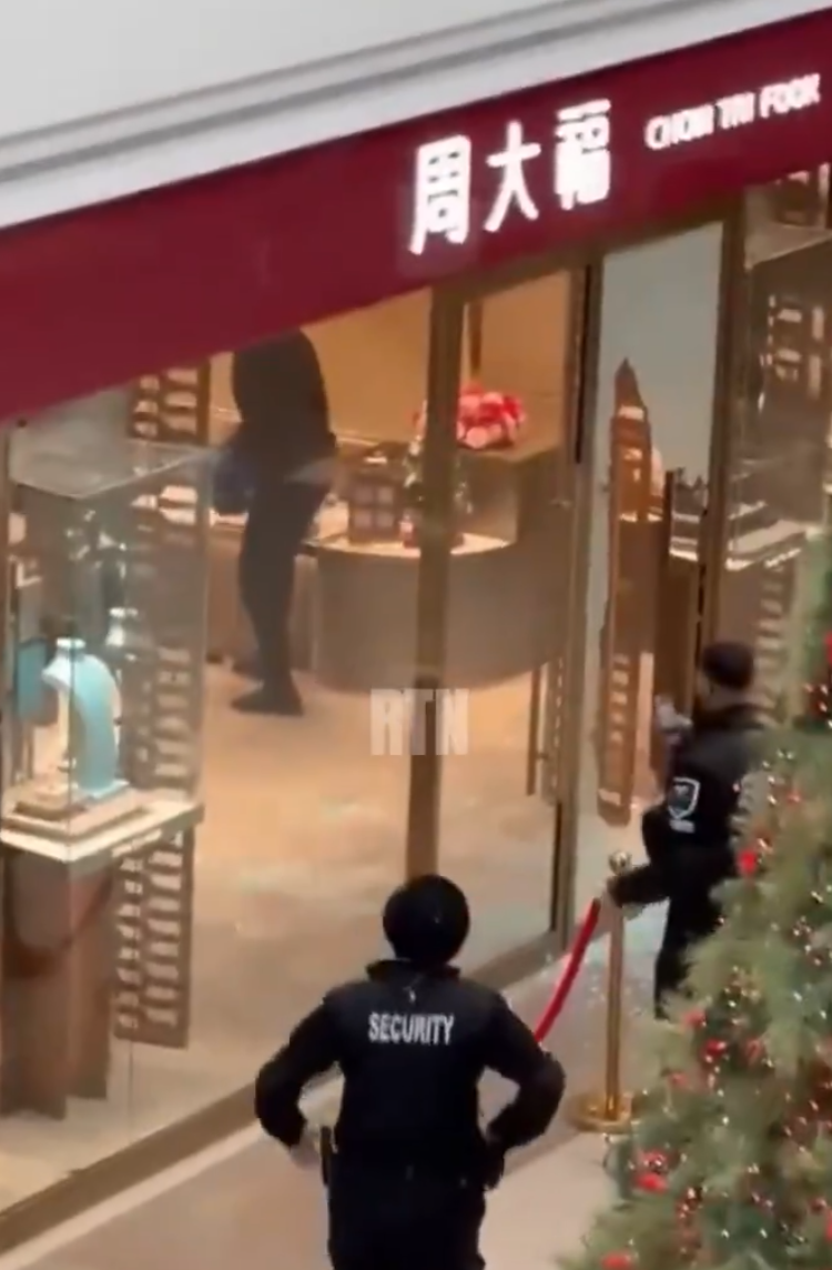 多倫多周大福遭6名劫匪搶走大量金飾珠寶,事發時有商場保安員在周大福門外眼白白看6名劫匪逃離現場,僅拍片取證沒有阻止。(影片截圖)