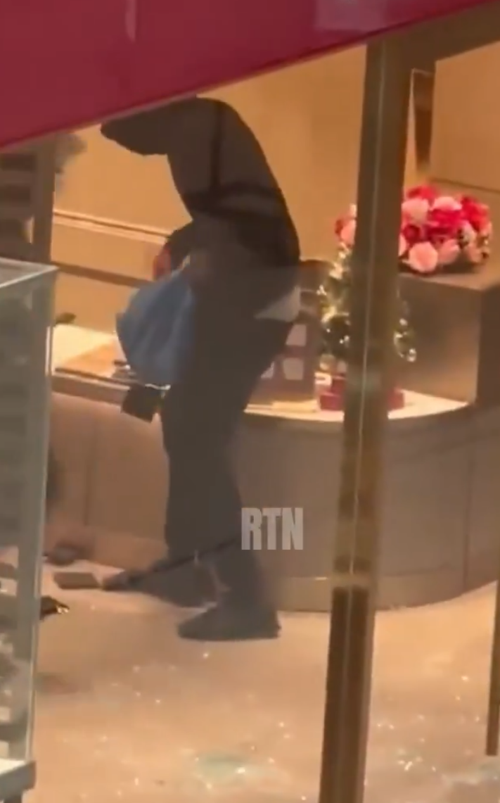 多倫多周大福遭6名劫匪搶走大量金飾珠寶,事發時有商場保安員在周大福門外眼白白看6名劫匪逃離現場,僅拍片取證沒有阻止。(影片截圖)