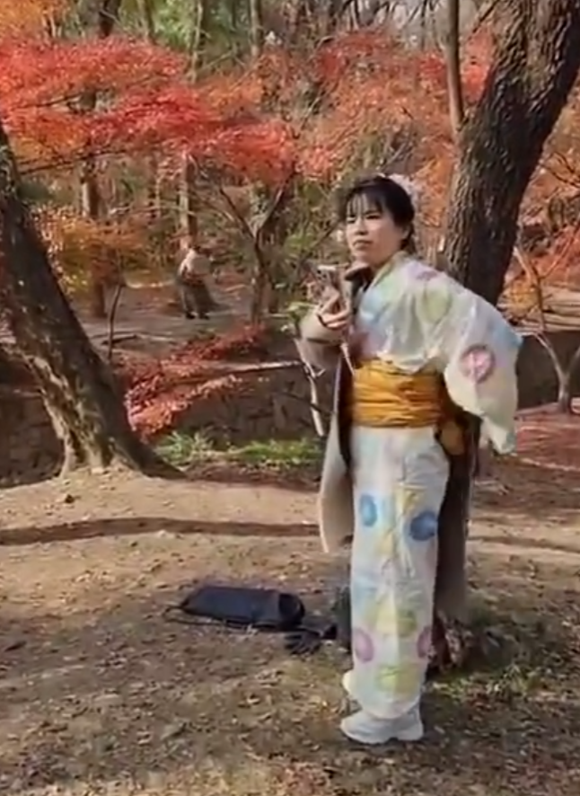 南京當地有女子穿上和服在南京中山植物公園拍照,但被途人怒斥後穿回外套遮蓋。(影片截圖)