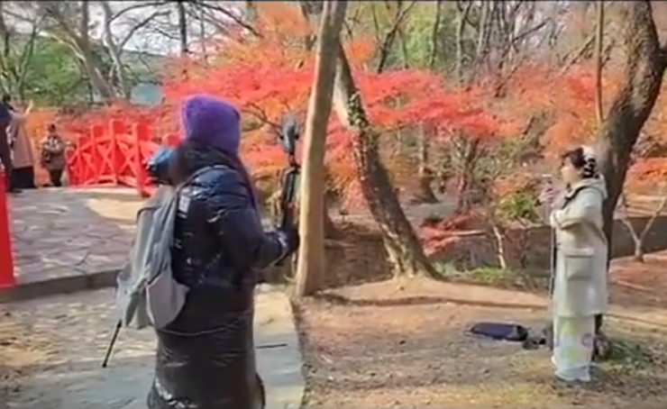 南京當地有女子穿上和服在南京中山植物公園拍照,但被途人怒斥後穿回外套遮蓋。(影片截圖)