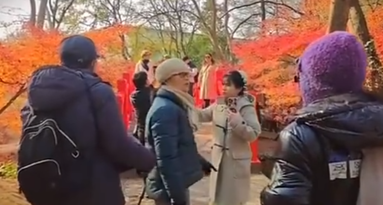 南京當地有女子穿上和服在南京中山植物公園拍照,但被途人怒斥後穿回外套遮蓋。(影片截圖)