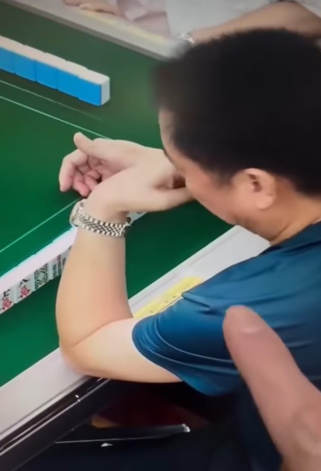 該段約42秒影片顯示一名中年男子在麻雀館打牌時,左手從口中拿出預先準備好的貼紙