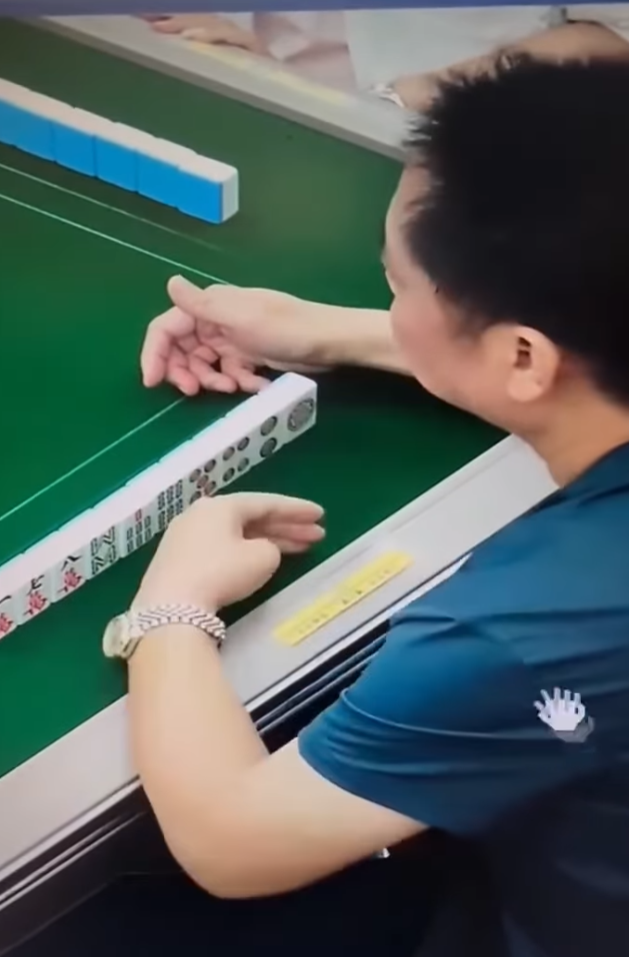 該段約42秒影片顯示一名中年男子在麻雀館打牌時,左手從口中拿出預先準備好的貼紙