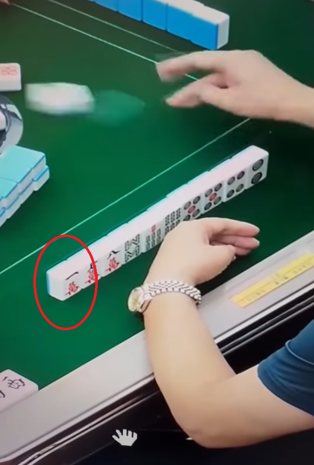 及後右手拿牌再出牌時,左手把貼紙貼在一隻雀麻牌之上,頓時令「一萬」變「六萬」