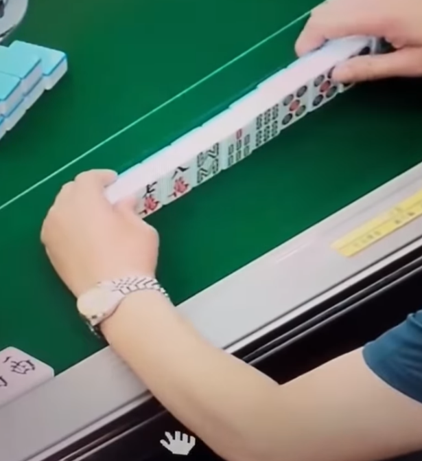 及後右手拿牌再出牌時,左手把貼紙貼在一隻雀麻牌之上,頓時令「一萬」變「六萬」