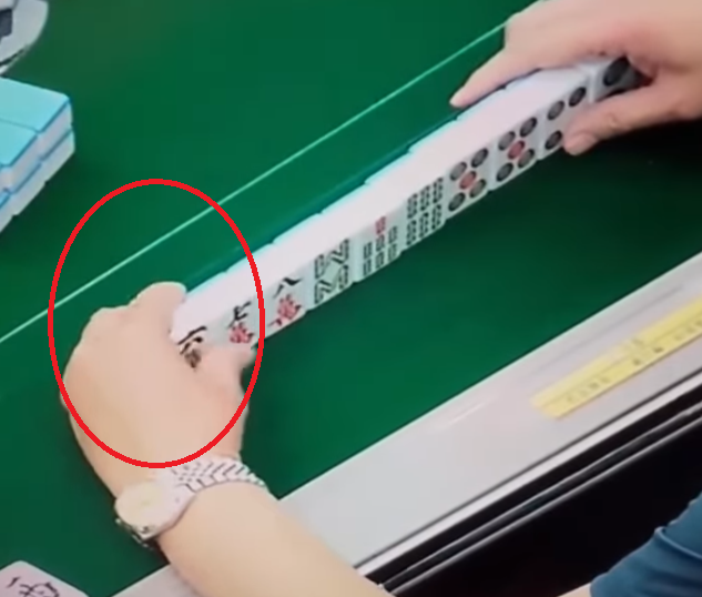 及後右手拿牌再出牌時,左手把貼紙貼在一隻雀麻牌之上,頓時令「一萬」變「六萬」