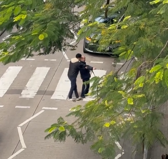 樂富一名司機主動落車攙扶一位持柺杖的老翁橫過斑馬線,兩線的車龍均耐心靜待(影片截圖)