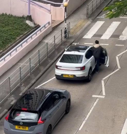 樂富一名司機主動落車攙扶一位持柺杖的老翁橫過斑馬線,兩線的車龍均耐心靜待(影片截圖)