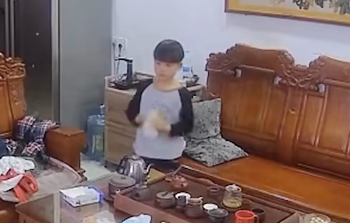 男童蓋上杯蓋後抱住杯身用力上下搖晃幾下