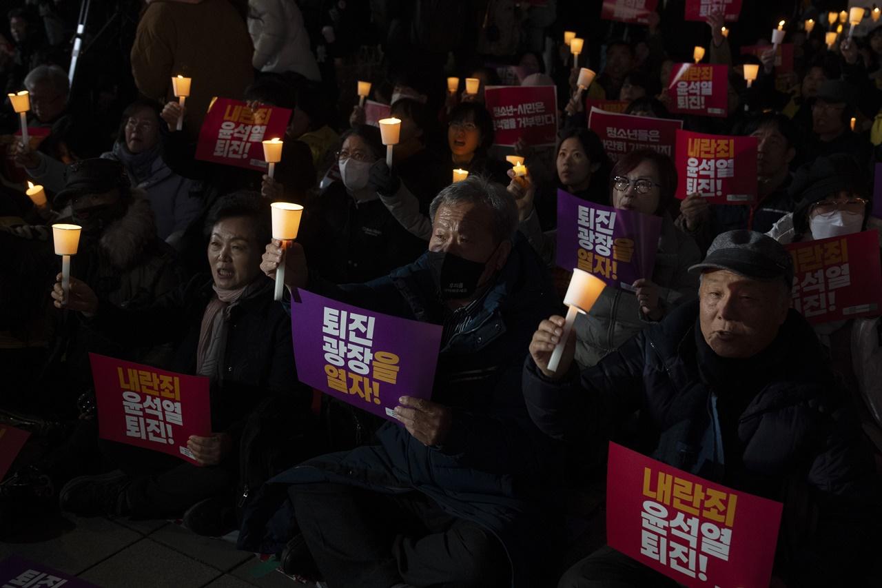 首爾市內多個地點,包括國會大樓和光化門廣場都有民眾舉起燭火示威集會,要求尹錫悅立即下台。(AP)