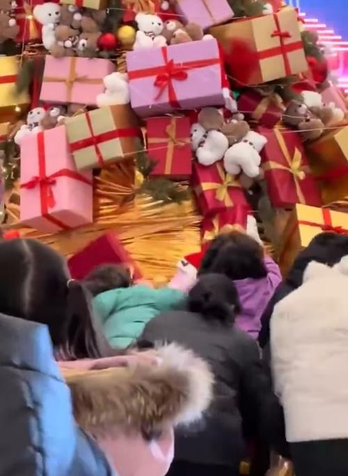 網上影片顯示,一群人圍著聖誕樹伸手去扯下裝飾盒,當中有男有女,有老有少。(微博)