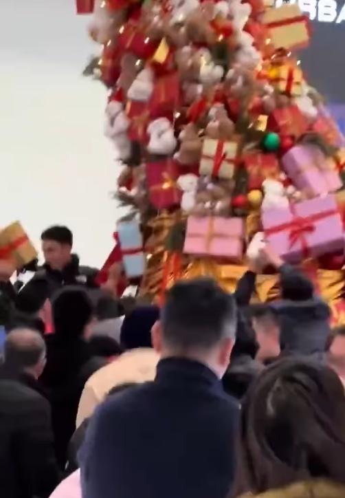 網上影片顯示,一群人圍著聖誕樹伸手去扯下裝飾盒,當中有男有女,有老有少。(微博)