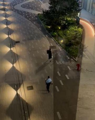 元朗半裸男在街頭持刀揮舞「黑旗」,隨後被兩名警員跟隨。(網片截圖)