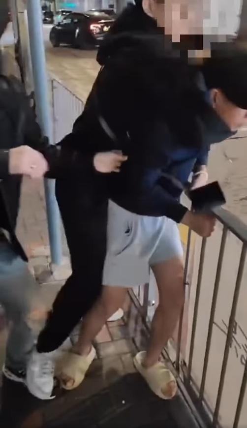短褲男被後面的男子箍頸。(網片截圖)