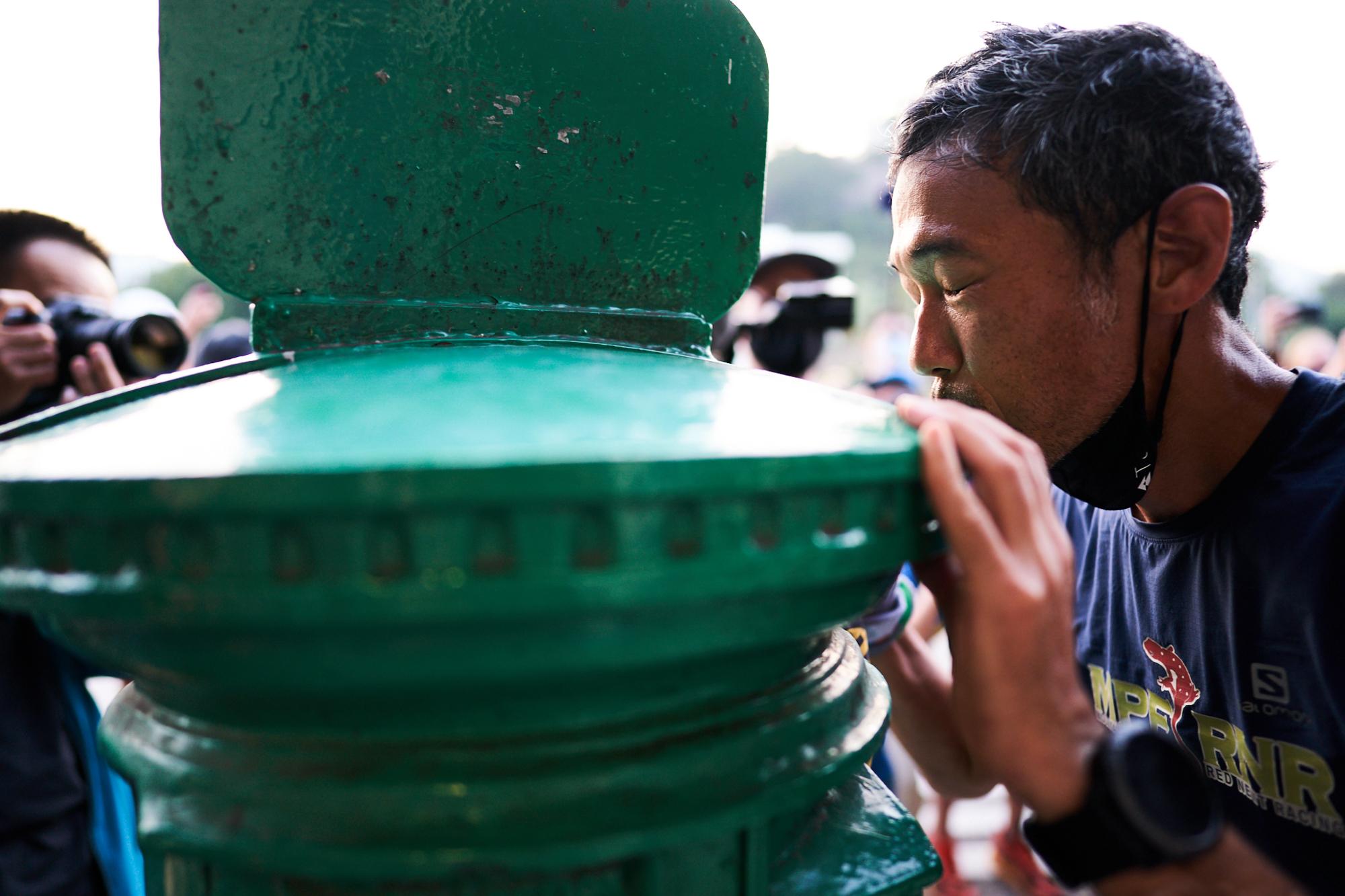 完賽跑手親吻終點站的郵筒,是「香港四徑超級挑戰」的傳統。(《香港四徑大步走》劇照)
