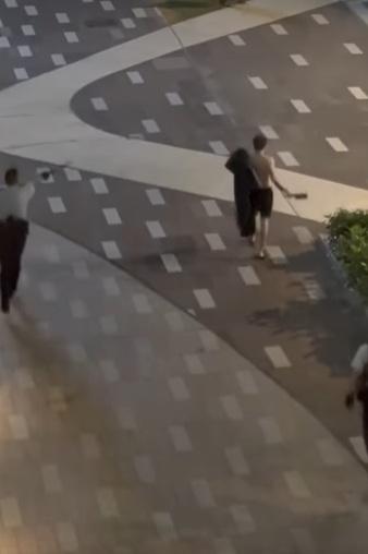 元朗半裸男在街頭持刀揮舞「黑旗」,隨後被兩名警員跟隨。(網片截圖)