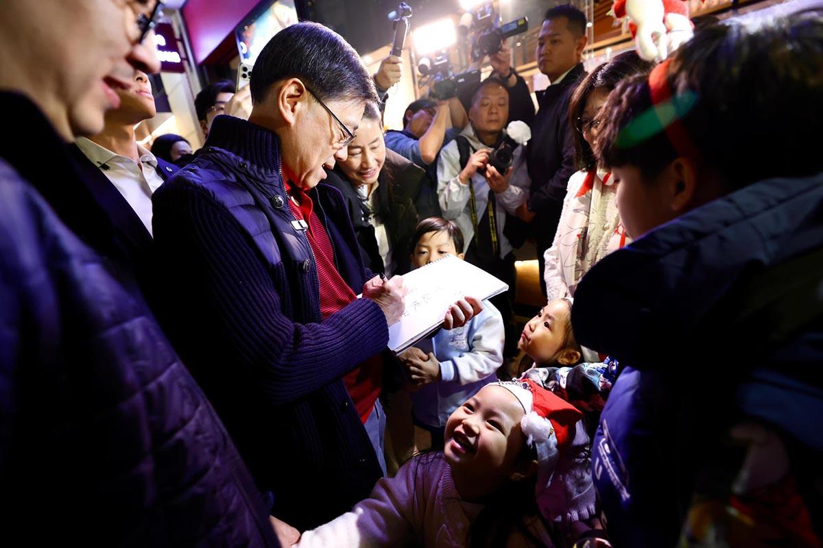 李家超為小朋友簽名。(李家超FB)