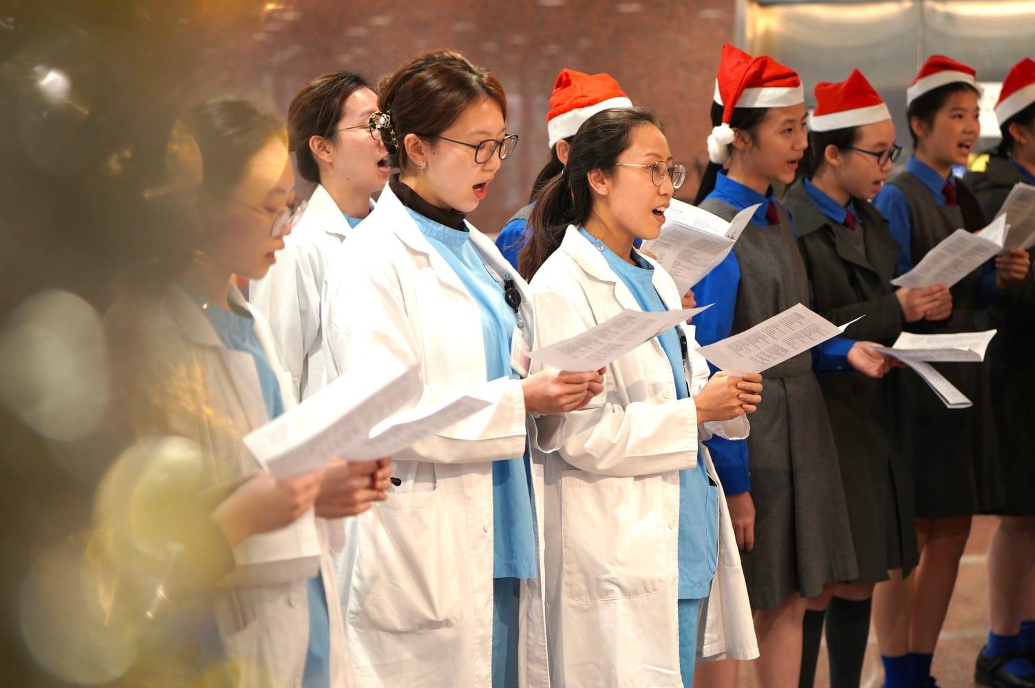 女拔學生去伊院同醫護人員一齊報佳音。(伊利沙伯醫院提供)