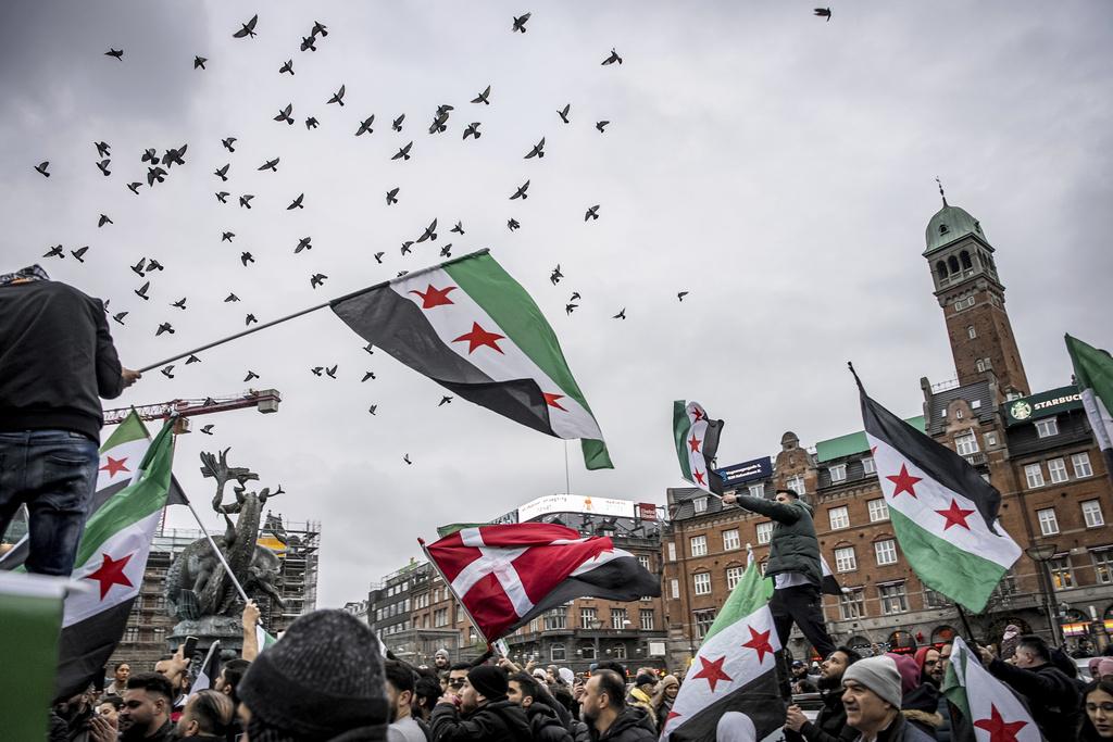 丹麥首都哥本哈根有民眾上街,慶祝巴沙爾政權倒台。(美聯社)