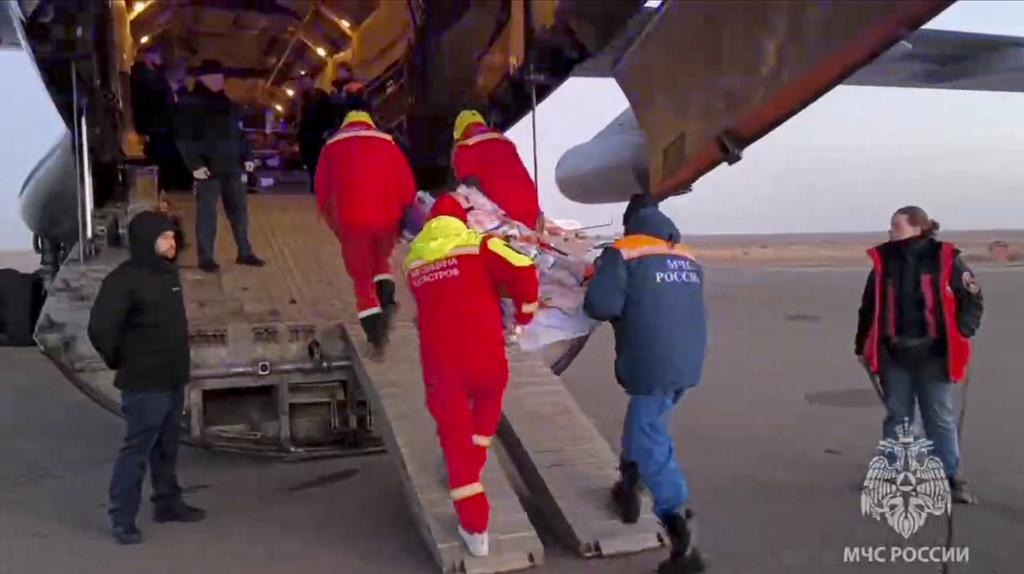 救援人員把傷者送上運輸機。(美聯社)