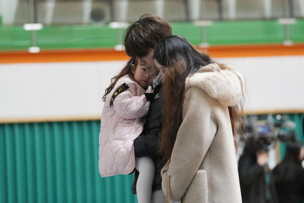 南韓多地設置臨時靈堂,一家人致祭時相擁安慰。(美聯社)