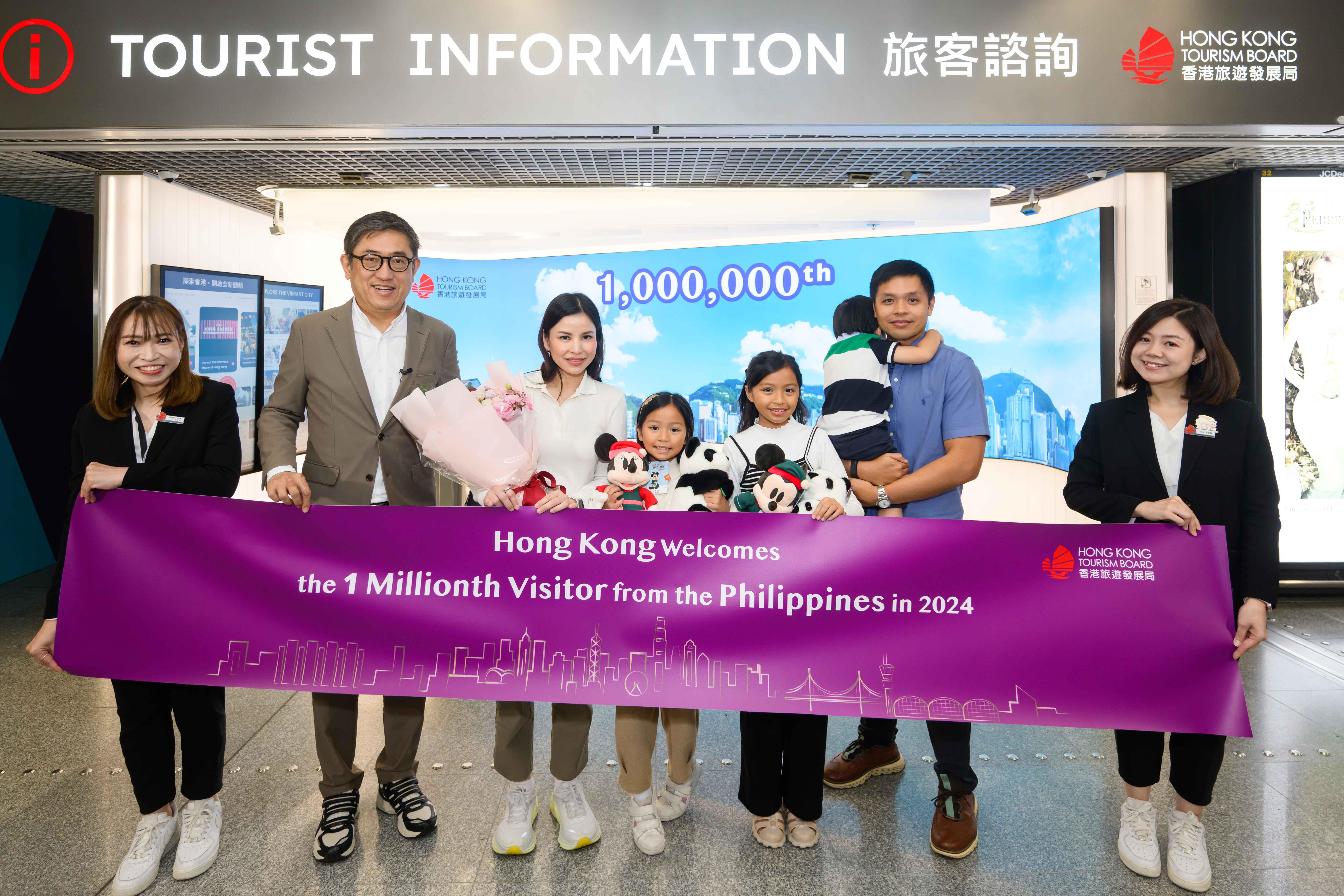 旅發局總幹事程鼎一(左二)在香港國際機場歡迎第一百萬名菲律賓旅客 Miguel Linao(右二)、其太太 Ana Linao (左三)及三名子女 (旅發局提供)