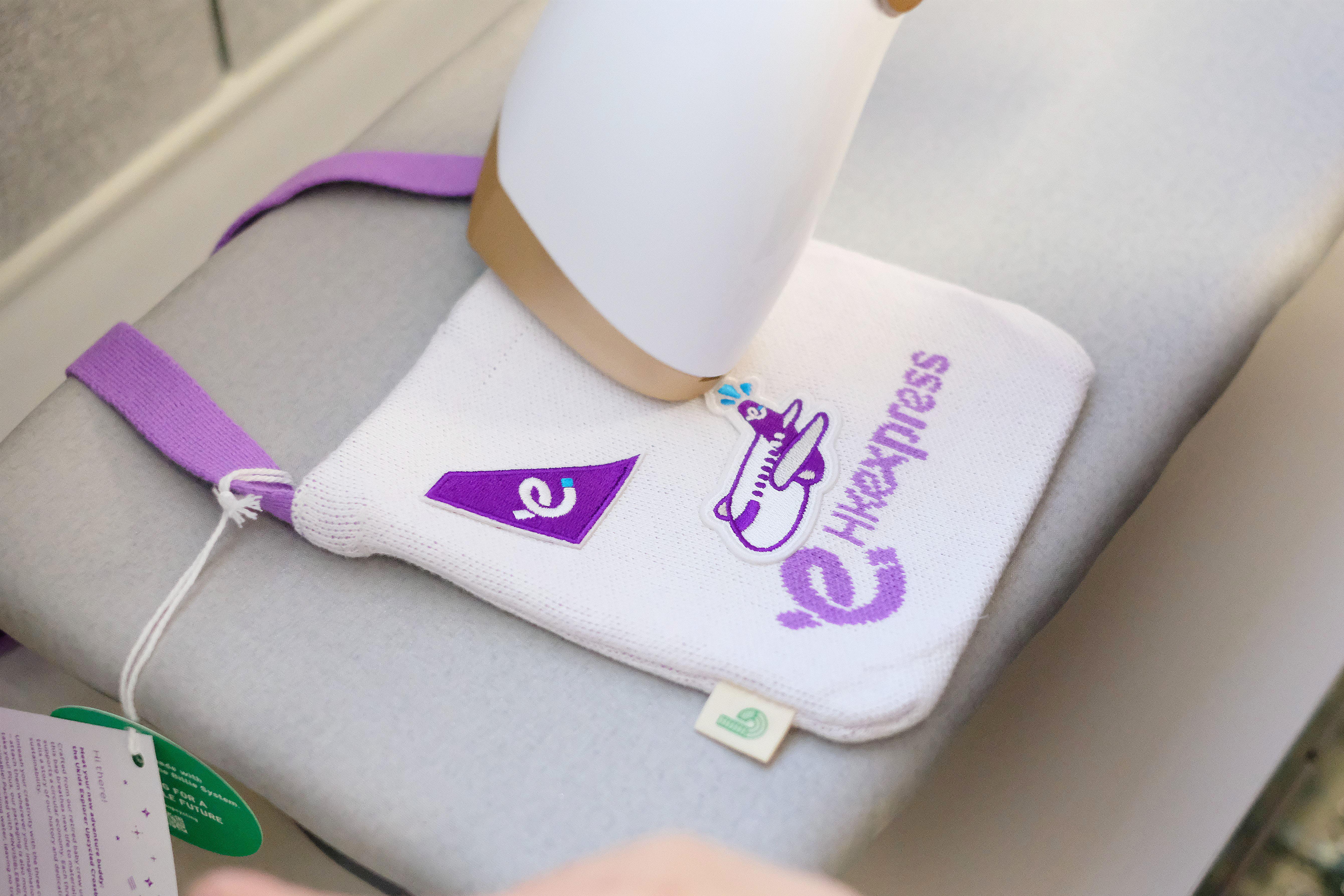 「Ukids 小探索家升級再造單肩包」設計充滿童趣,以旅遊元素與香港快運品牌插圖為特色,並附送三個可熨貼於袋面的刺繡襟章(品牌標誌及飛機造型),讓使用者自由裝飾,展現個人創意。