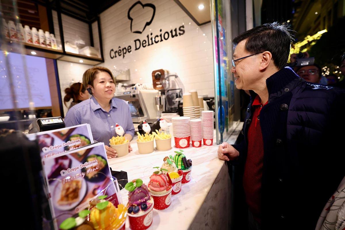 李家超在灣仔與商戶交流並購買一份薯條。(李家超FB)