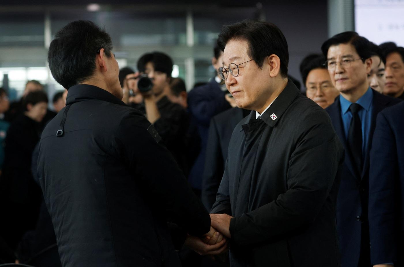 南韓最大在野共同民主黨領袖李在明到務安機場慰問家屬。(路透社)