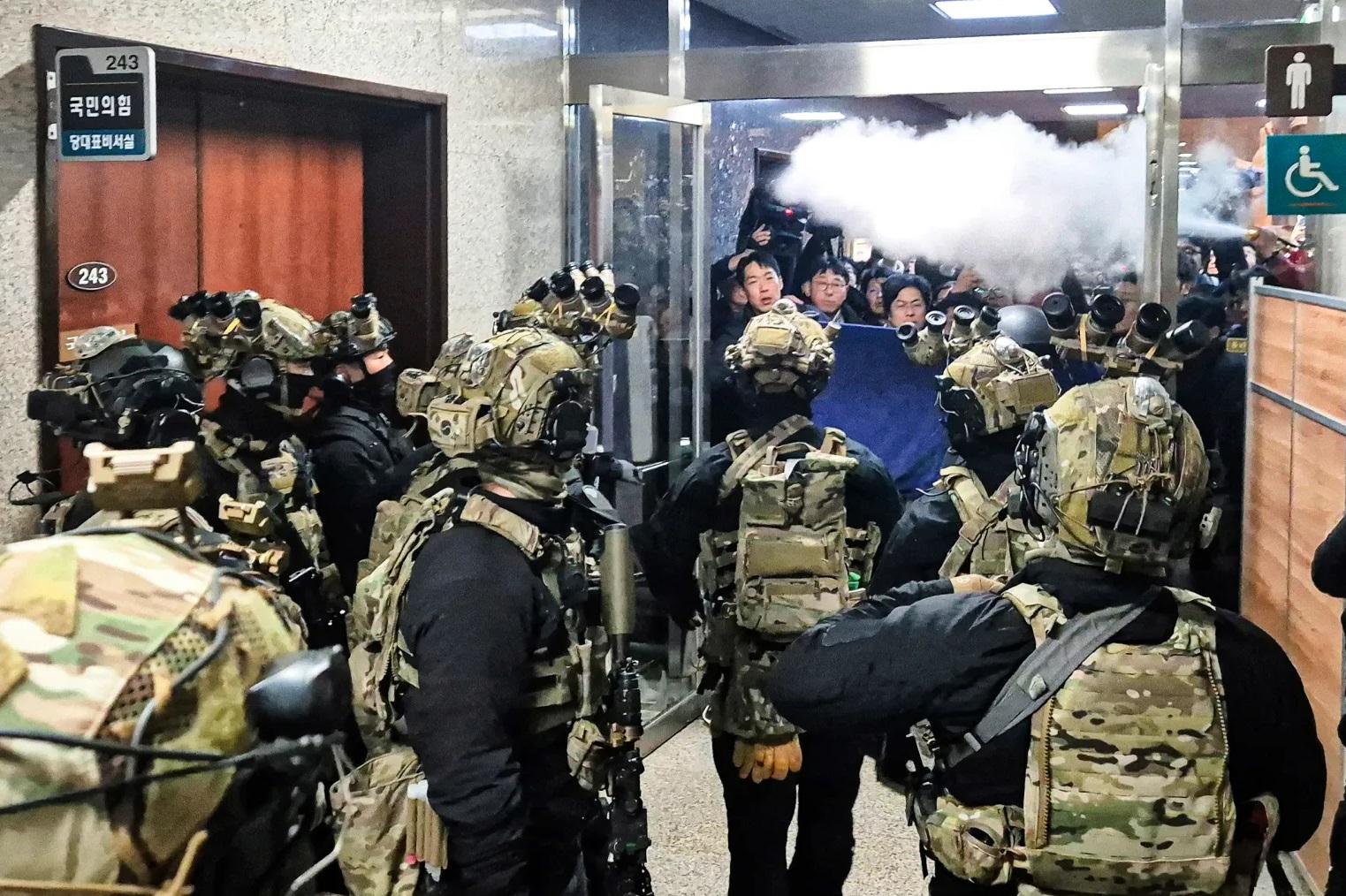 南韓士兵周二晚進入國會後與職員對峙,有人向士兵噴滅火筒煙霧。(美聯社)
