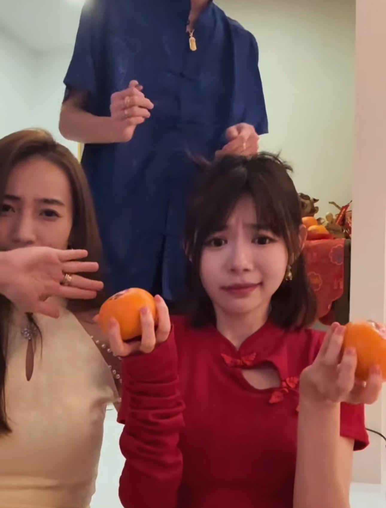 林明禎托住兩個柑拍片。