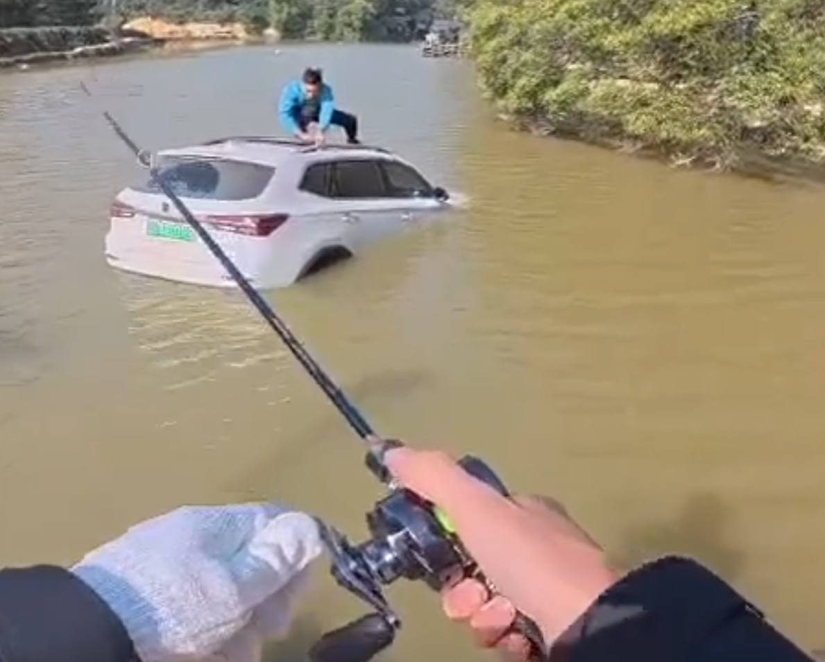 深圳有釣魚人士遇到一輛車墮湖,車主站在車頂處境危險。於是他伸出魚桿向車頂抛出魚絲,借助風力和水的浮力,將車輛「釣回」拉到岸邊。(影片截圖)