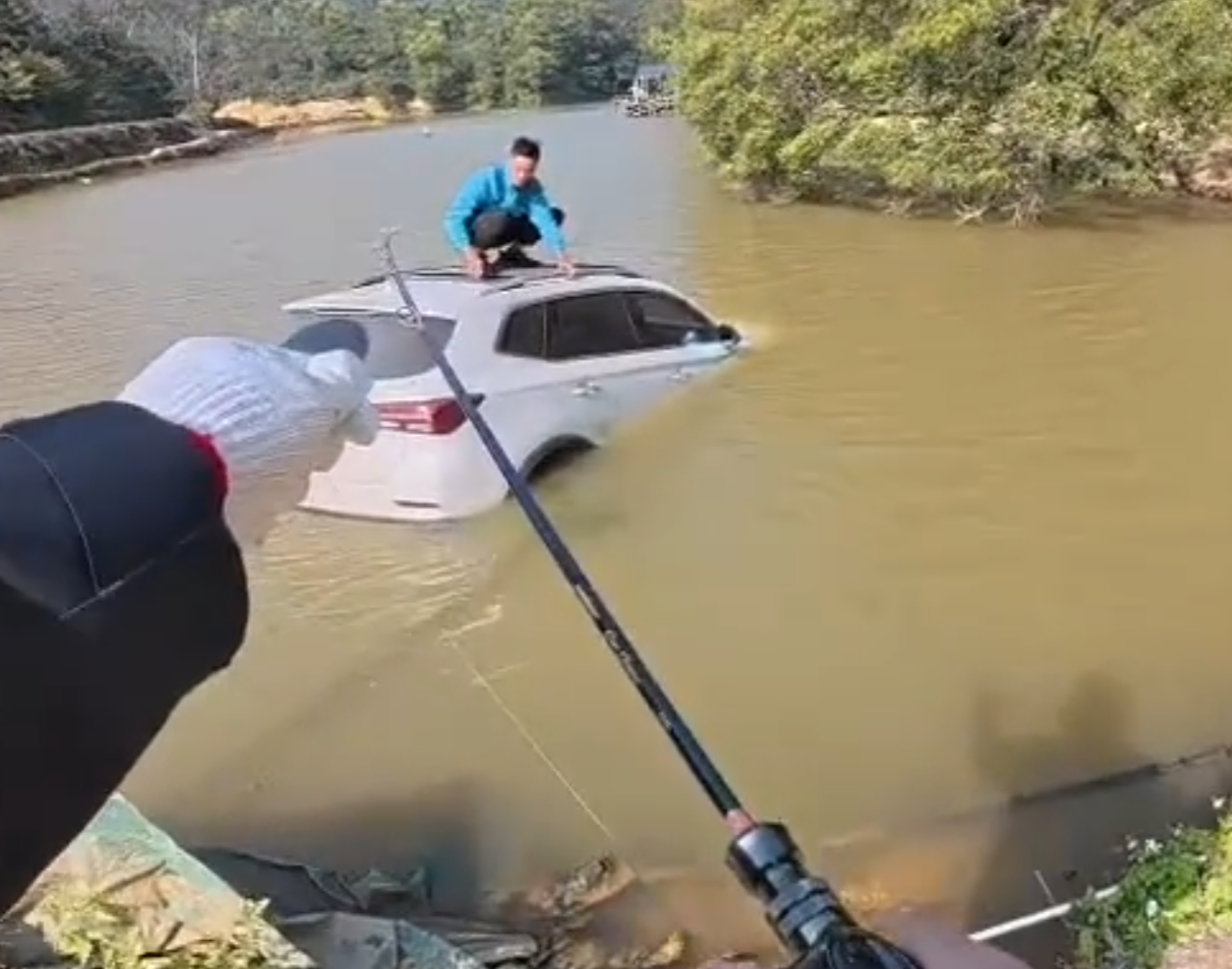 深圳有釣魚人士遇到一輛車墮湖,車主站在車頂處境危險。於是他伸出魚桿向車頂抛出魚絲,借助風力和水的浮力,將車輛「釣回」拉到岸邊。(影片截圖)